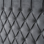 Dark grey tufted velvet headboard close-up.